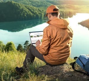 Remote freelancer work in nature. Beautiful view with sunset and lake in the background